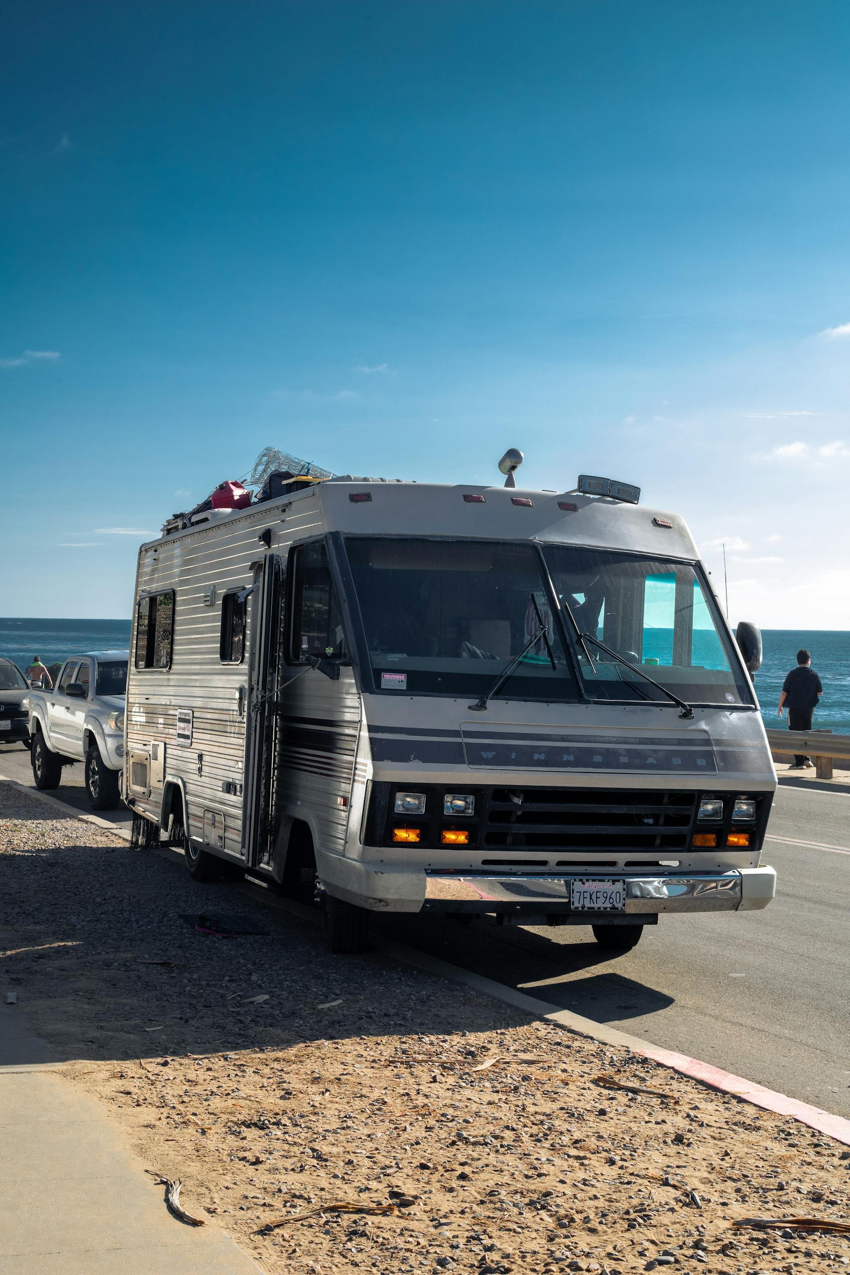 Classic RV on coastal road under clear blue sky