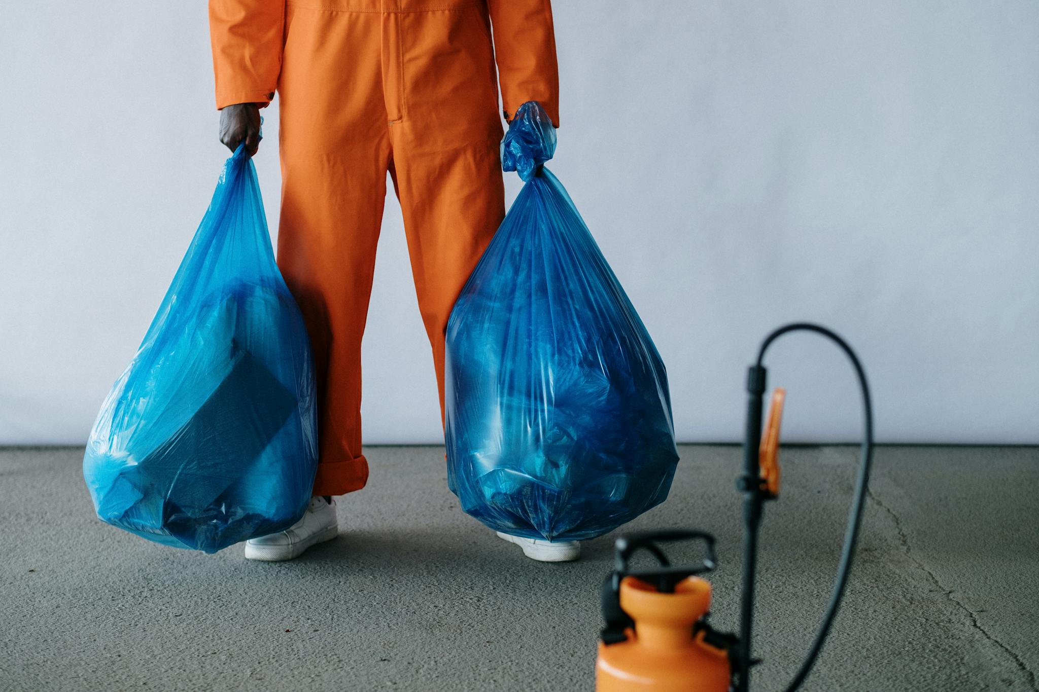 Worker near large blue dumpster enclosure